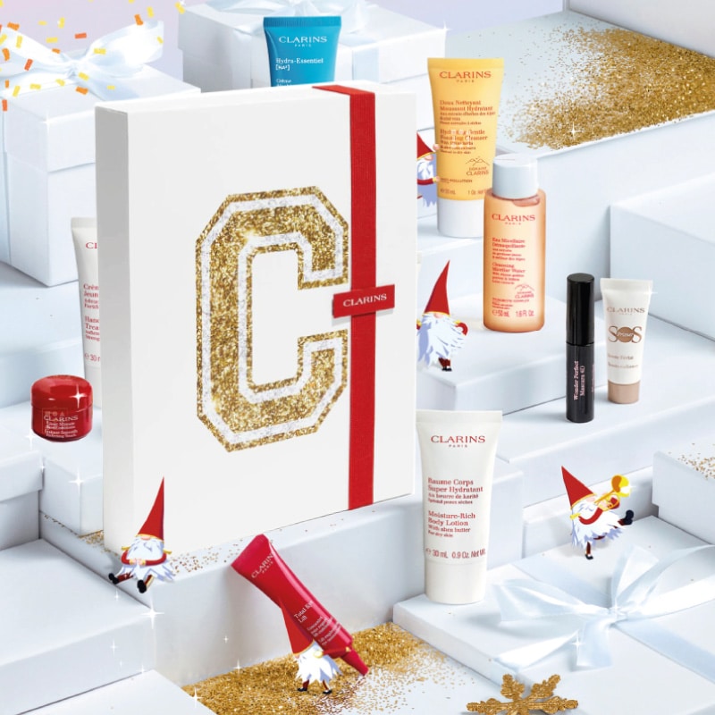 coffret beauté blanc C de clarins en or avec ruban rouge calendrier de l'avent clarins 12 cosmétiques visage et maquillage