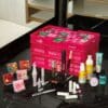 calendrier de l'avent maquillage benefit 2024 présenté dans un panier rose contenant 24 produits et accessoires maquillage